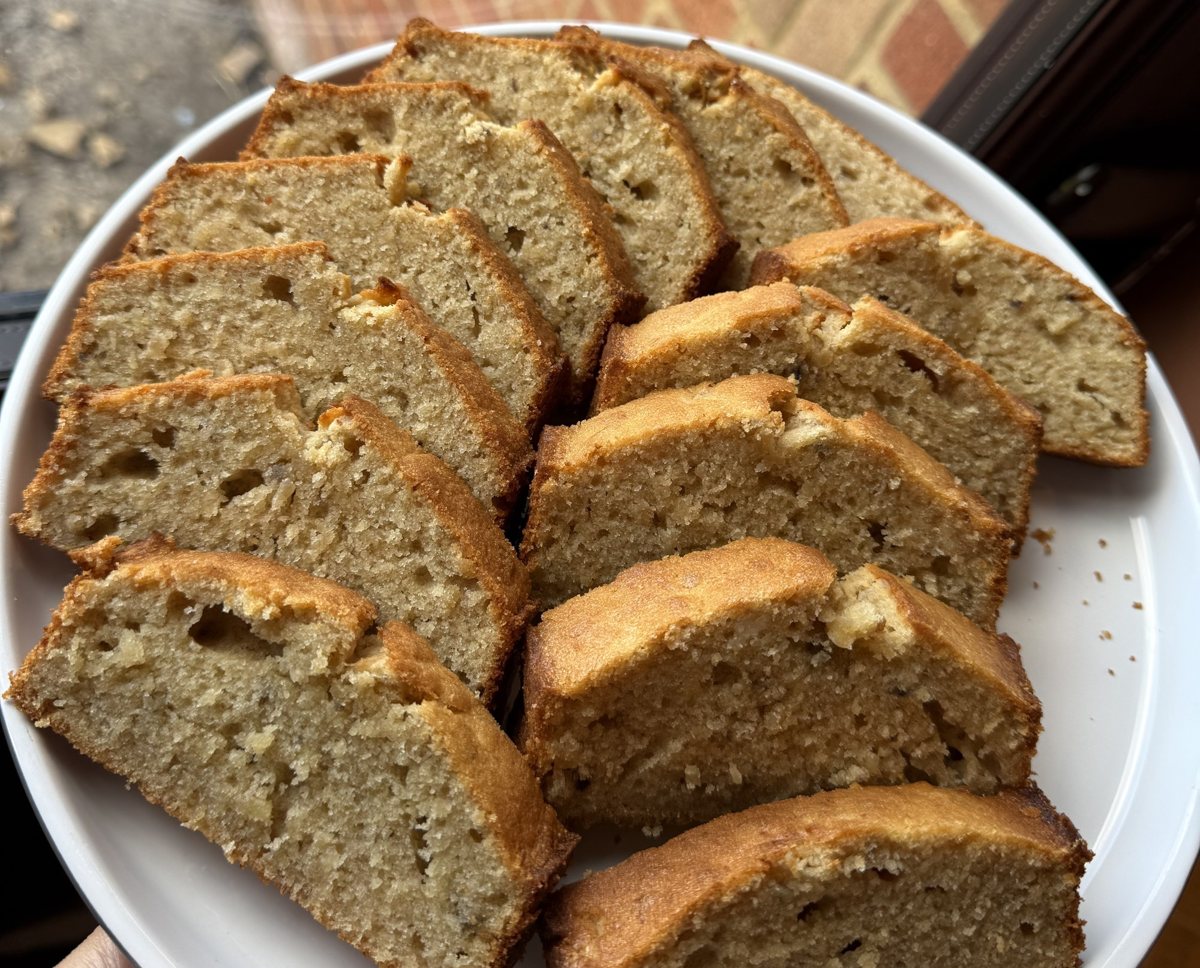 Thick slices of banana and peanut butter loaf fanned out on a white plate
