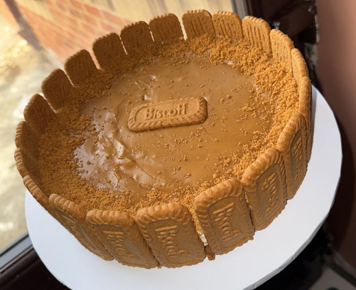 A round Biscoff cheesecake ringed with Biscoff biscuits, topped with Biscoff spread and biscuit crumb